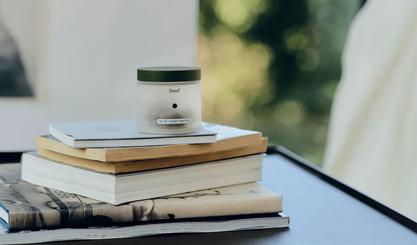 Candle on a stack of books with a blurred natural background